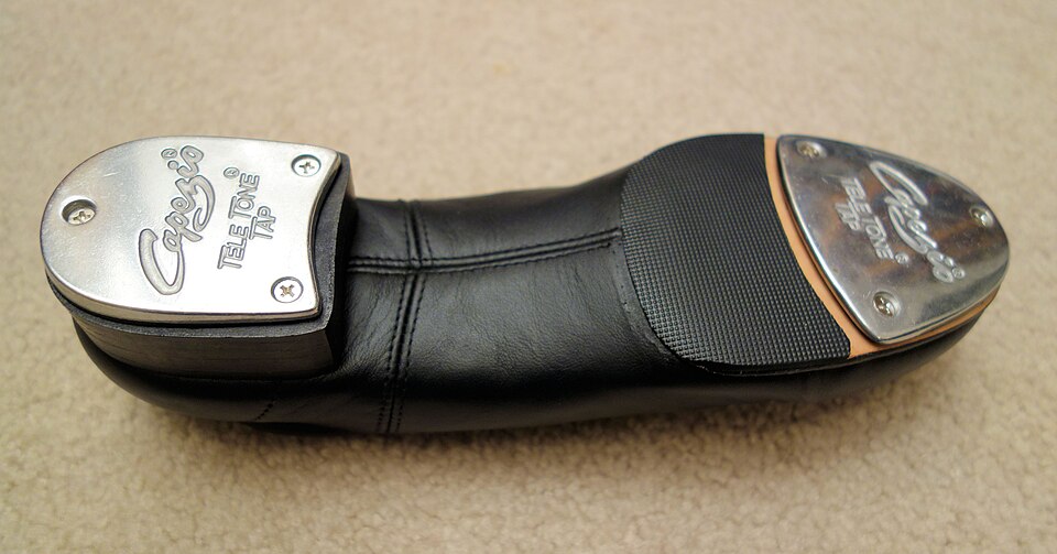 The bottom of a tap dance shoe showing the metal plates on the heel and toe