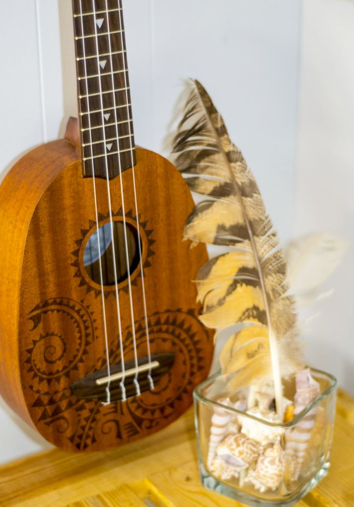 A pineapple-shaped ukulele with decorative Maori-inspired designs