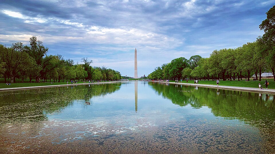 The Washington Monument reflected in the Reflecting Pool with a blue sky