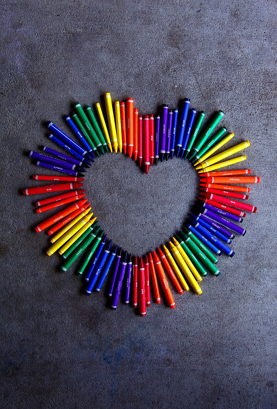 Colorful crayons arranged in a rainbow heart shape