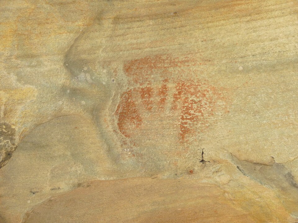 An ancient red handprint on a cave wall in Australia
