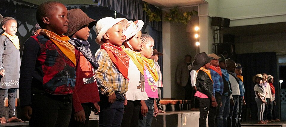 Children in costumes performing on stage during a school play