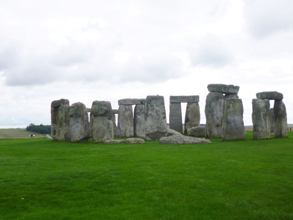 The stone circle of Stonehenge standing on green grass in England