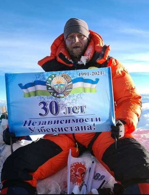 A climber at the snowy summit of Mount Everest, the tallest mountain on Earth