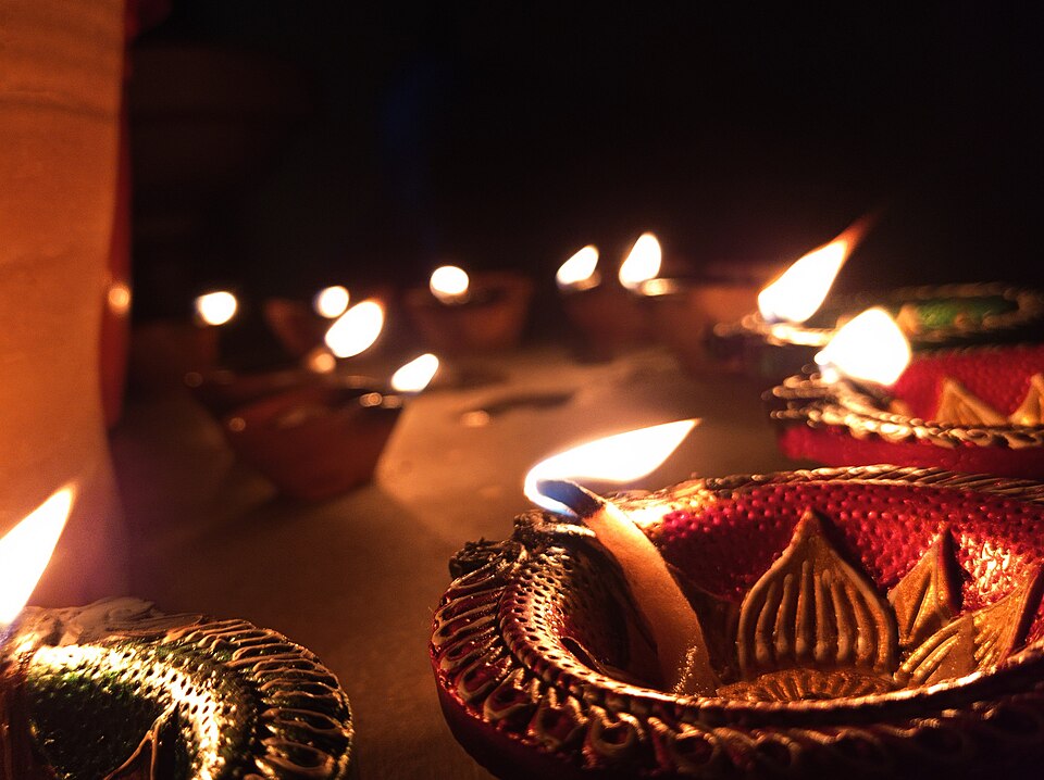 Beautiful clay lamps called diyas glowing with warm flames during Diwali