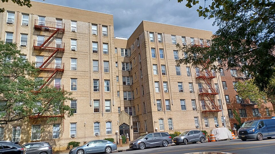 A brick apartment building in Brooklyn, New York, with characteristic red fire escapes on the outside