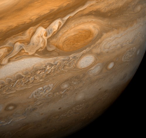 A close-up view of Jupiter’s Great Red Spot, a giant storm swirling with orange and white clouds