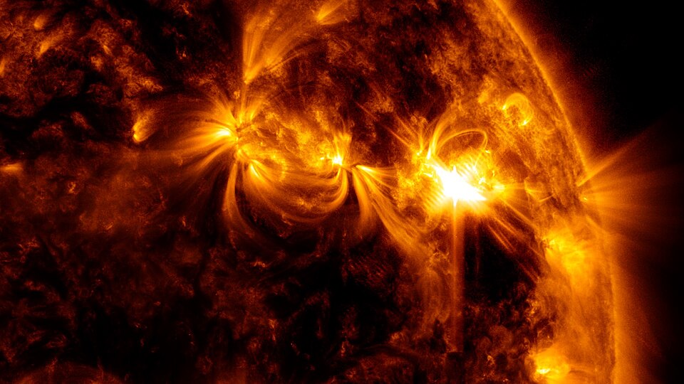 A close-up of the Sun showing a bright solar flare erupting from its glowing surface