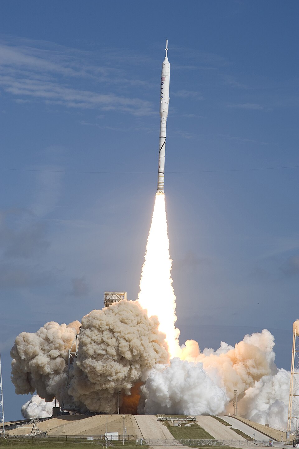 A rocket launching into the sky with bright flames and huge clouds of exhaust