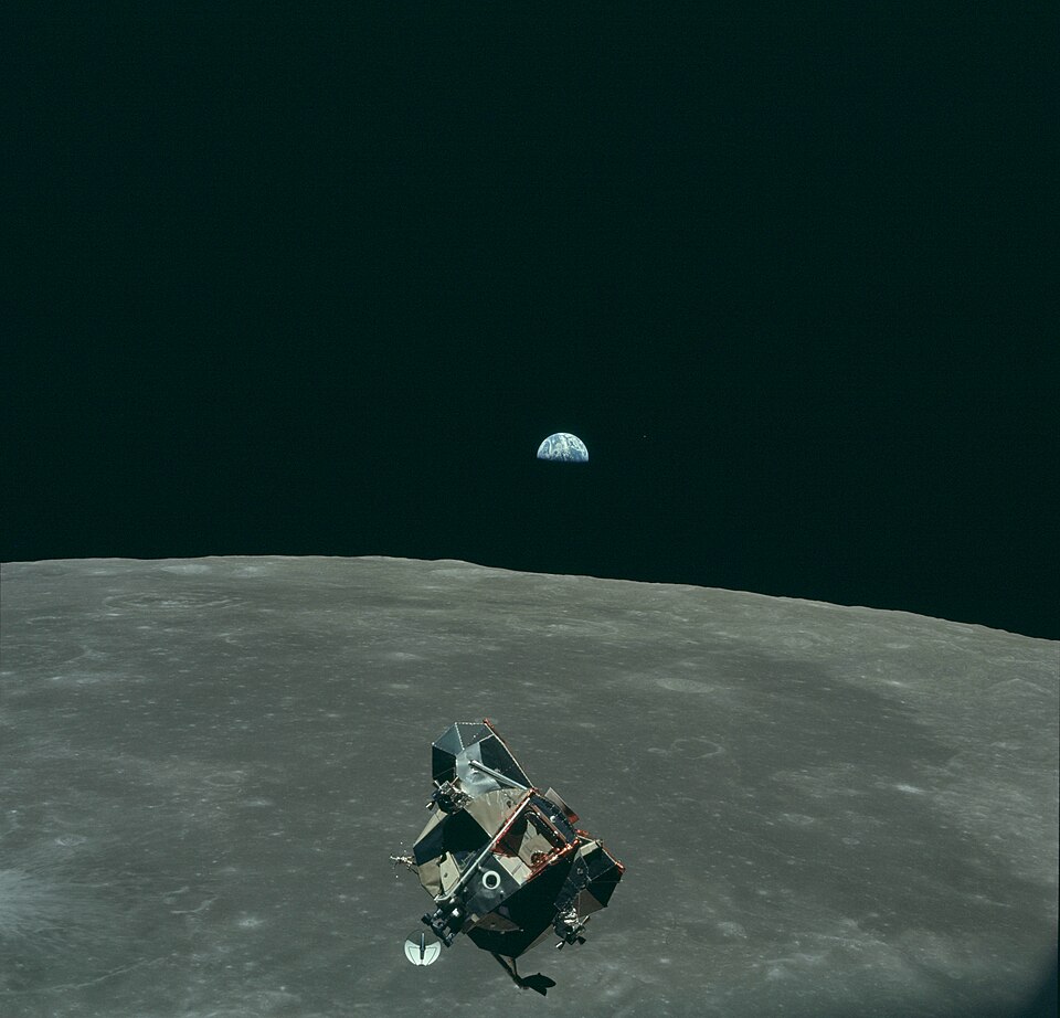 The Apollo 11 Lunar Module in orbit above the Moon with Earth in the background